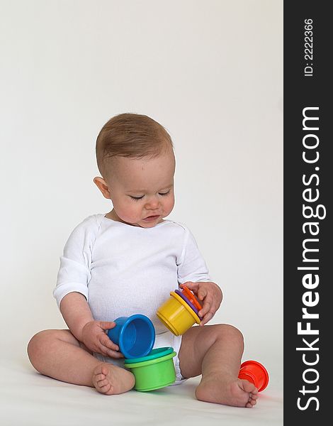 Image of adorable baby playing with stacking cups. Image of adorable baby playing with stacking cups