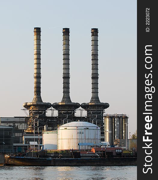 Three factory chimneys across the river while the ship is passing. Three factory chimneys across the river while the ship is passing