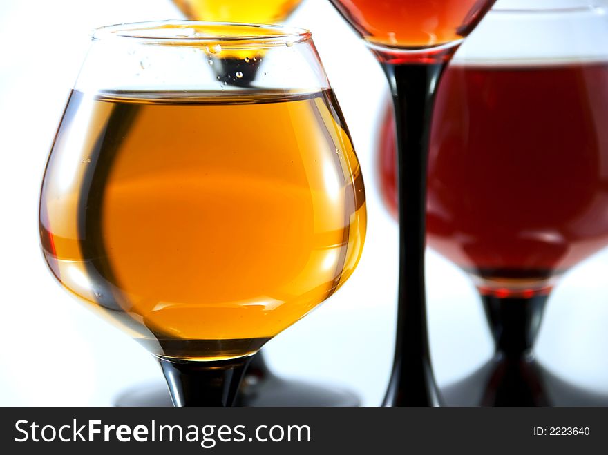 Beautiful glasses with juice with reflection on a white background