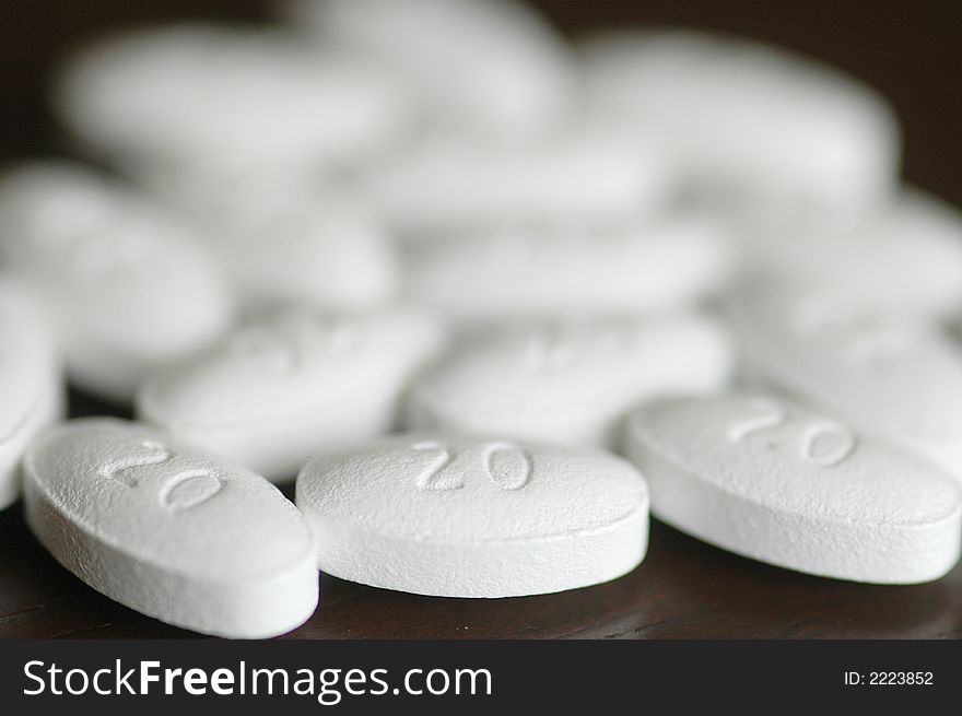 White pills spread out on a table. very narrow focus