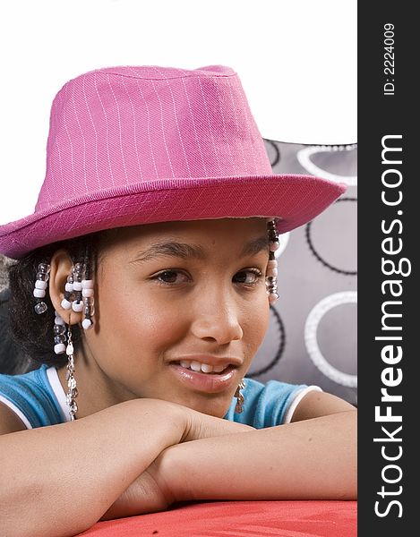 Cute african american girl resting head on hands and pink hat on head