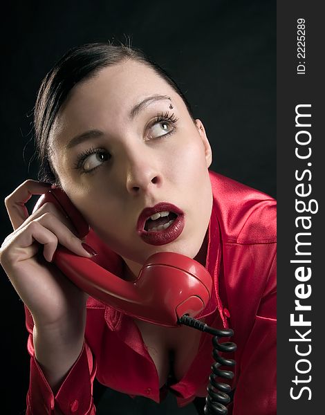Lady in red is talking by old red phone. Lady in red is talking by old red phone