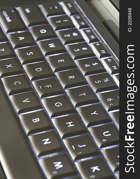 A closeup of a backlit computer keyboard with shallow depth of field.