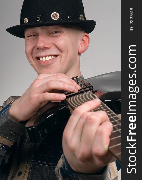 The musician smiles on a grey background