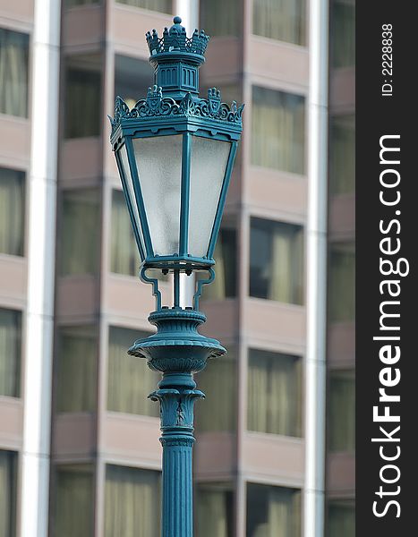 Old style street lamp with modern building background.