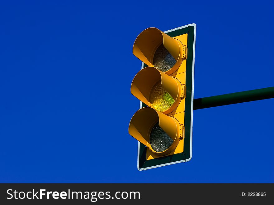 Yellow traffic light on blue sky