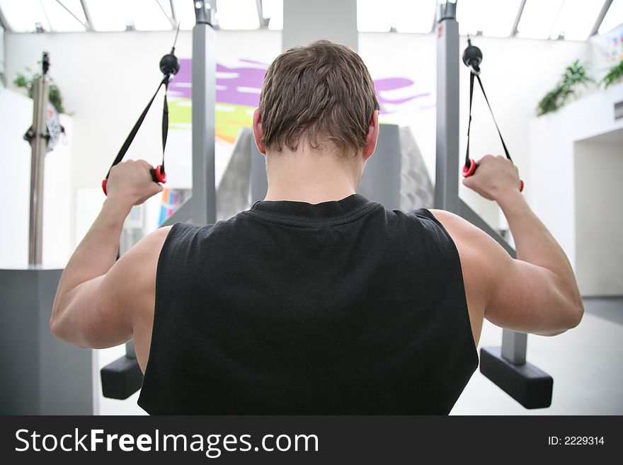 Body builder on physical training in fitness center. Body builder on physical training in fitness center