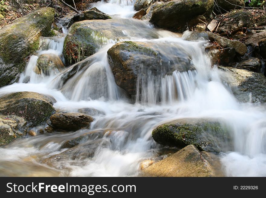 A little river falling between rocks in the mountains. A little river falling between rocks in the mountains