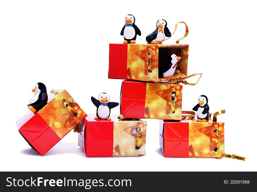 Happy penguins playing with gift boxes on white background