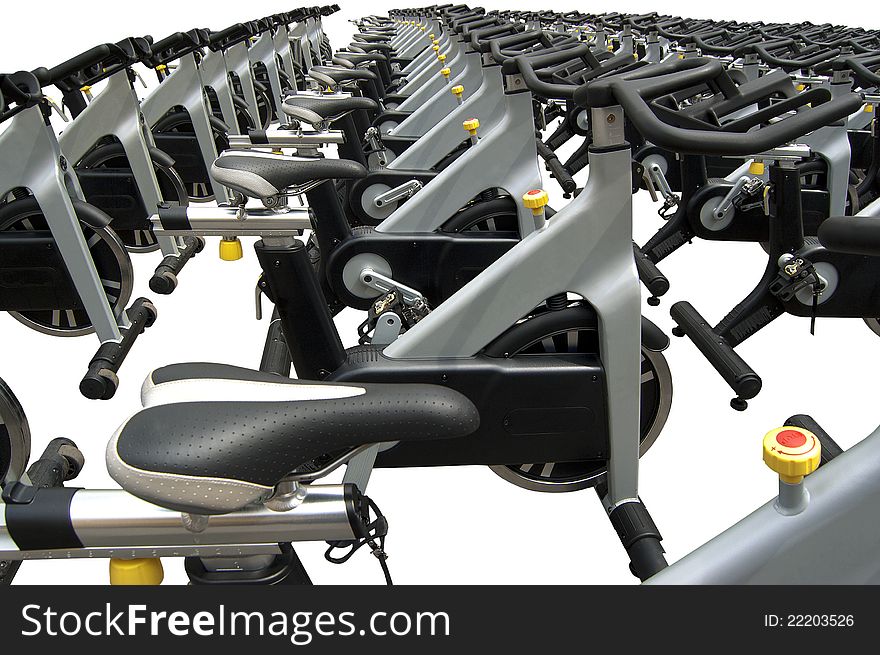 Group of aluminum spinning bikes outdoors on white background. Group of aluminum spinning bikes outdoors on white background