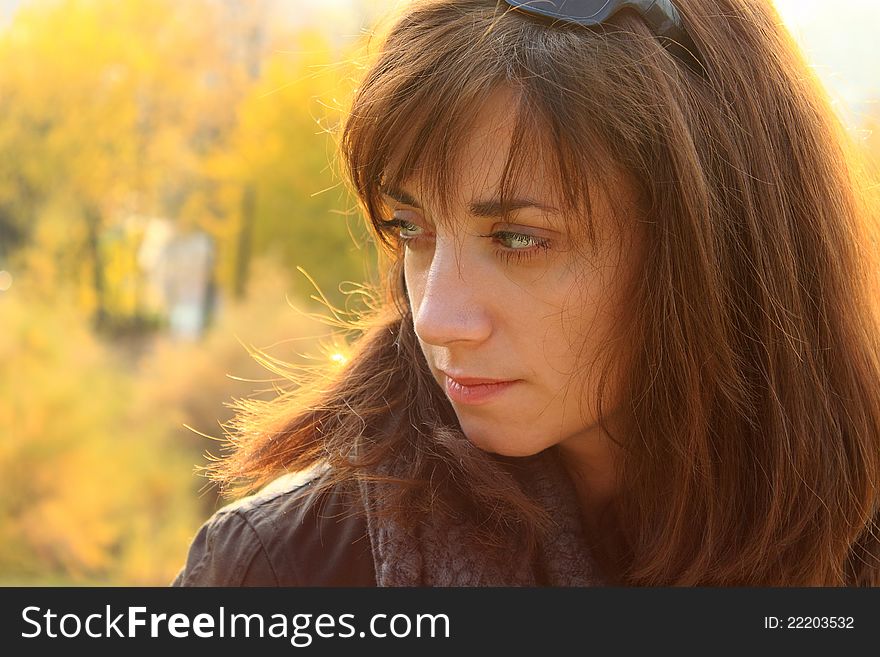 Portrait of a young women, with a thoughtful and pensive expression on her face, taken in the park in an autumn. Portrait of a young women, with a thoughtful and pensive expression on her face, taken in the park in an autumn