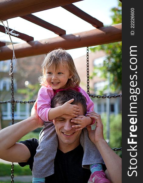 Little girl with her father is spending time at the park. Little girl with her father is spending time at the park.