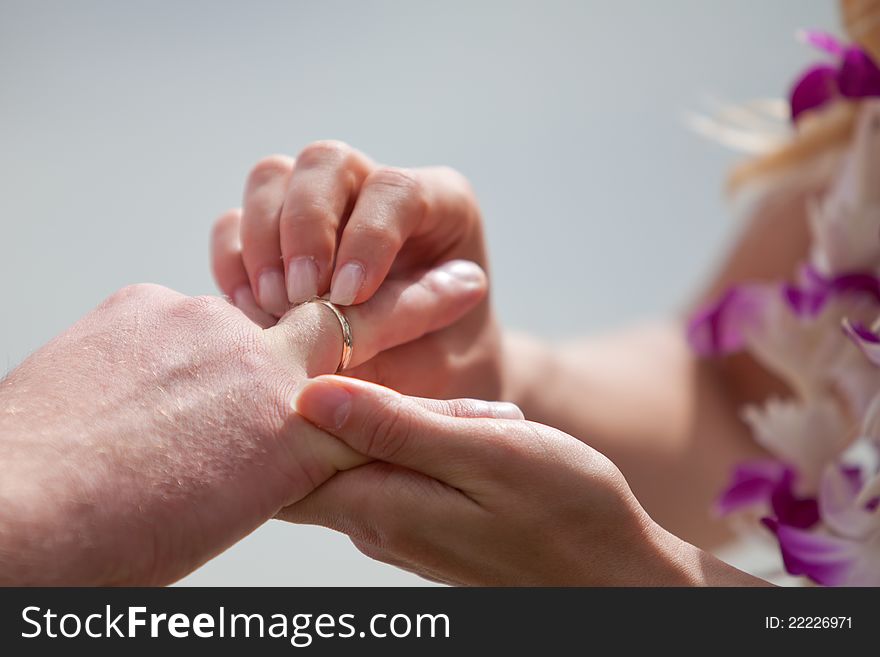 Bride putting a wedding ring on groom's finger. Bride putting a wedding ring on groom's finger