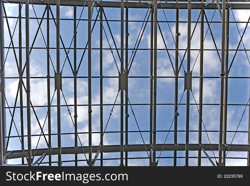 Blue sky with white clouds viewed through a metal ceiling construction. Blue sky with white clouds viewed through a metal ceiling construction