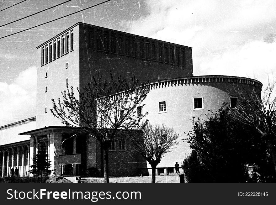 The Ankara Opera Building, which hosts performances by the Ankara State Opera and Ballet and Ankara State Theater was designed and built as an exhibition center and only later converted into an opera house. In 1933 the National Economy Community opened an international competition for the building stating that it had to be in modernist style. A proposal by Åževki Balmumcu received first prize and construction went ahead between 1933 and 1934. In 1948 Paul Bonatz converted the building into an opera house and his addition of traditional Turkish architectural details made it more â€œnational.â€ Balmumcu was not consulted about the buildingâ€™s renovation, which disappointed and professionally disturbed him for years to come. In the garden of the building there are sculptures of Leyla Gencer, CÃ¼neyt Gencer and Muhsin ErtuÄŸrul.

SALT Research, Harika-Kemali SÃ¶ylemezoÄŸlu Archive


GÃ¼nÃ¼mÃ¼zde hem Ankara Devlet Opera ve Balesi temsillerine ev sahipliÄŸi yapan hem de BÃ¼yÃ¼k Tiyatro adÄ±yla Ankara Devlet Tiyatrosu iÃ§in bir sahne olarak hizmet veren Ankara Opera BinasÄ±, ilk olarak bir sergi sarayÄ± olarak inÅŸa edildi, daha sonra opera binasÄ±na dÃ¶nÃ¼ÅŸtÃ¼rÃ¼ldÃ¼. BinanÄ±n tasarÄ±mÄ±na, Milli Ä°ktisat ve Tasarruf Cemiyetiâ€™nin 1933â€™te aÃ§tÄ±ÄŸÄ± uluslararasÄ± bir yarÄ±ÅŸma sonunda karar verildi. YarÄ±ÅŸmanÄ±n duyurusunda, tasarÄ±mÄ±n modernist Ã¼slupta olmasÄ± gerektiÄŸi Ã¶zellikle belirtildi. Birinci seÃ§ilerek mimarÄ± Åževki Balmumcuâ€™ya bÃ¼yÃ¼k bir prestij kazandÄ±ran proje 1933-1934 yÄ±llarÄ±nda uygulandÄ±. Paul Bonatz, 1948â€™te binayÄ± iÅŸlevinden Ã§ok farklÄ± olarak bir opera binasÄ±na Ã§evirdi; Geleneksel TÃ¼rk MimarlÄ±ÄŸÄ±â€™ndan detaylar ekleyerek binayÄ± â€œmillÃ®leÅŸtirdiâ€. TasarladÄ±ÄŸÄ± binanÄ±n kendisine hiÃ§ danÄ±ÅŸÄ±lmadan, dÃ¶nemin eÄŸilimi olan Ä°kinci Ulusal MimarlÄ±kâ€™a uygun hÃ¢le getirilmesi, Balmumcuâ€™yu mesleki anlamda olumsuz etkiledi. Caddeye paralel uzanan ve birbirini dik kesen iki kitleden oluÅŸan binanÄ±n bahÃ§esinde Leyla Gencer, CÃ¼neyt Gencer ve Muhsin ErtuÄŸrulâ€™un heykelleri bulunmaktadÄ±r.

SALT AraÅŸtÄ±rma, Harika-Kemali SÃ¶ylemezoÄŸlu ArÅŸivi

Repository: SALT Research

Rights Info: This material can be used under Creative Commons Attribution-NonCommercial-NoDerivatives 4.0 International &#x28;CC BY-NC-ND 4.0&#x29; license.