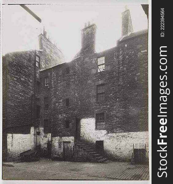 Photograph of the back view of a Three storey tenement building. There are three carts in front of the building and a set of stairs leading up to the first floor back entrance. The bottom section of the building is white washed. At one of the third storey windows there is an empty washing line.

digital.nls.uk/74506882. Photograph of the back view of a Three storey tenement building. There are three carts in front of the building and a set of stairs leading up to the first floor back entrance. The bottom section of the building is white washed. At one of the third storey windows there is an empty washing line.

digital.nls.uk/74506882
