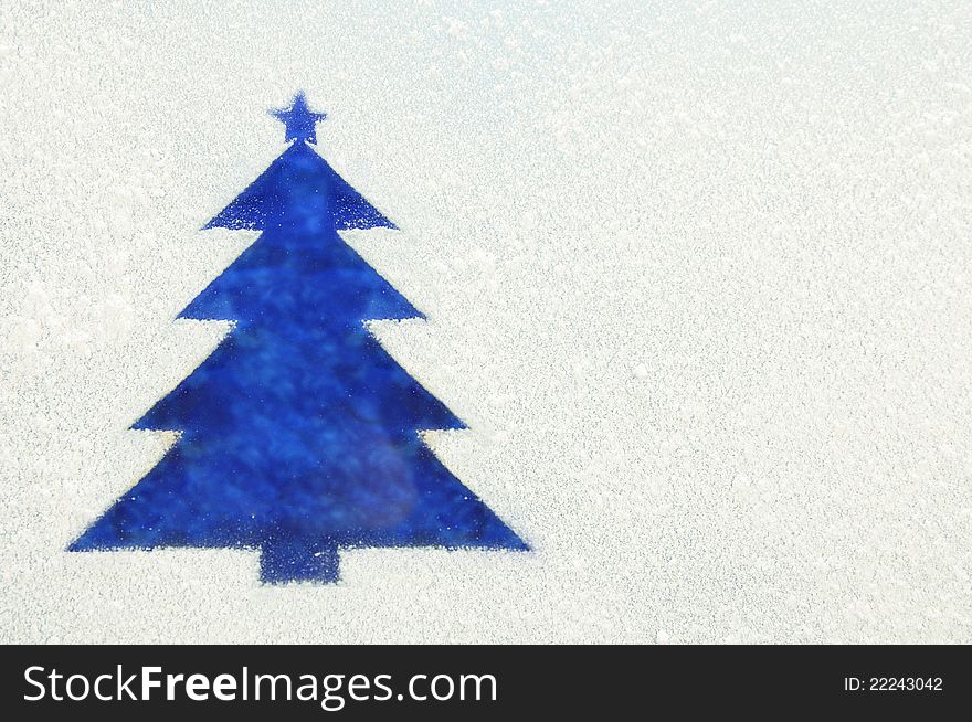 Photography of a Christmas Tree on a frozen window. Symbol of new year.