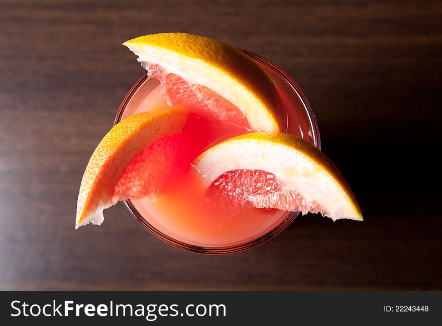 Grapefruit slices and a glass with juice
