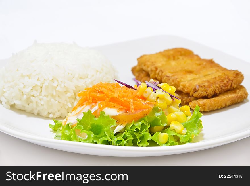 Close up vegetable salad, with fried fish and rice, on dish white.