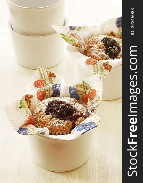 Fresh tasty berry muffins decorated in small bowls with colorful napkins