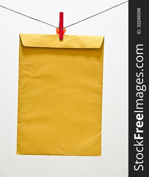 Envelope brown paper and red clothespin hanging on a clothesline. Envelope brown paper and red clothespin hanging on a clothesline