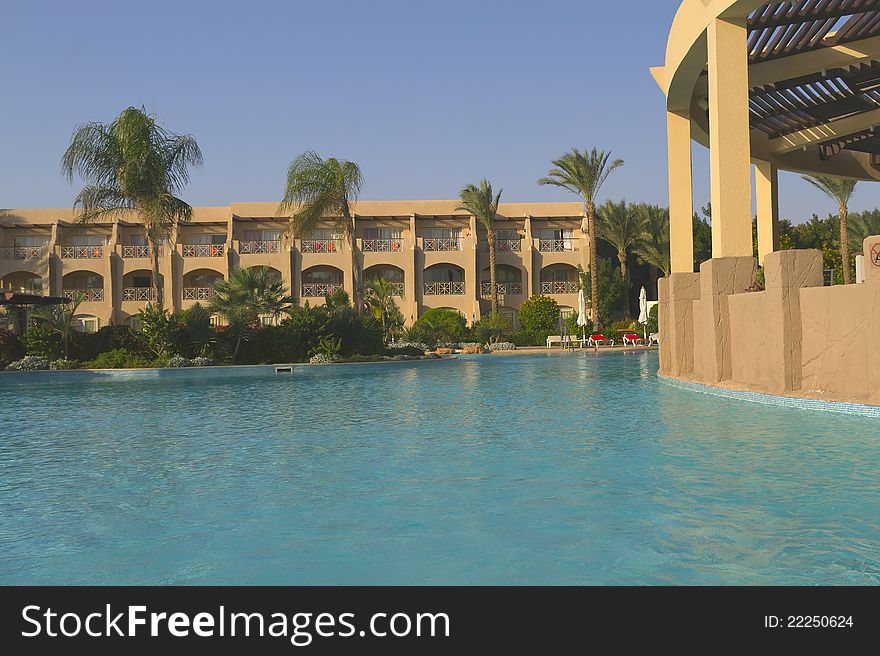 Luxury Resort Pool with palm trees in the early morning light. Luxury Resort Pool with palm trees in the early morning light.