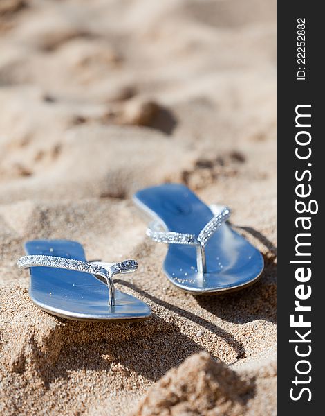 A pair of flip-flops floating on the sand on a beach. A pair of flip-flops floating on the sand on a beach