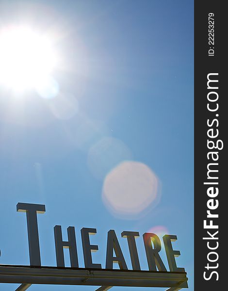 Theater sign below the blue sky and sunlight. Theater sign below the blue sky and sunlight
