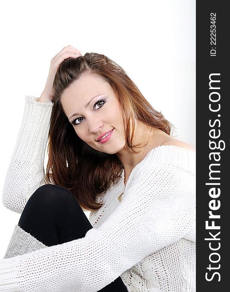 Portrait of the young beautiful girl on a white background in a white sweater