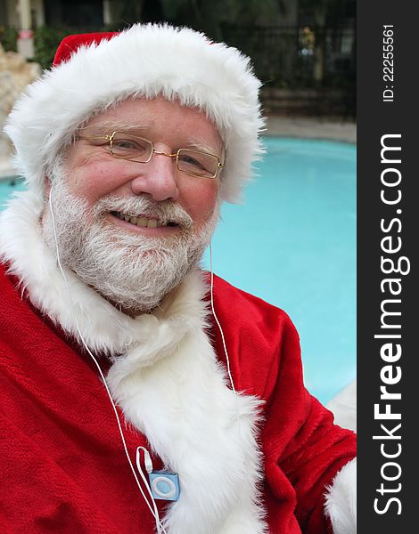 Santa relaxing next to a pool listening to his ipod. Santa relaxing next to a pool listening to his ipod.