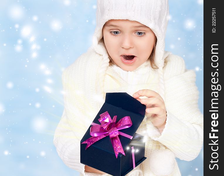 Little girl in cap opens the box