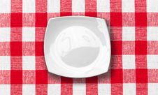 White Plate On Red Checked Fabric Tablecloth Royalty Free Stock Photography White Plate On Red Checked Fabric Tablecloth Royalty Free Stock Photography