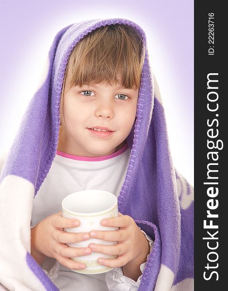 Beautiful little girl with a purple blanket and a cup of tea