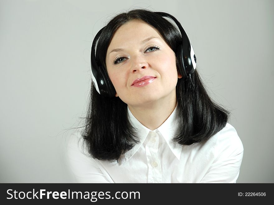 A young office worker girl in headphones operator. A young office worker girl in headphones operator