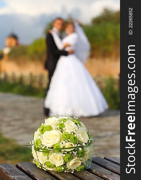 Bridal bouquet and the couple in the background. Bridal bouquet and the couple in the background