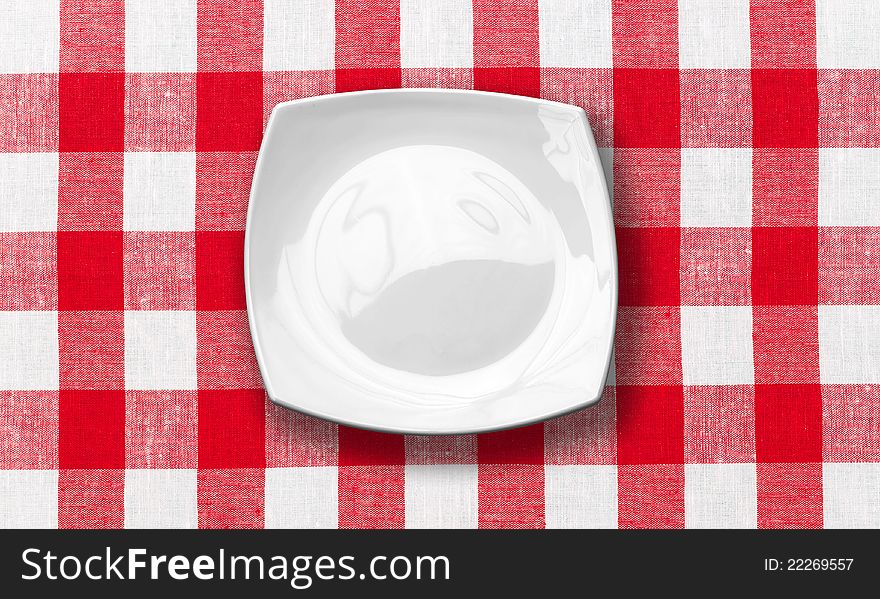 White plate on red checked fabric tablecloth