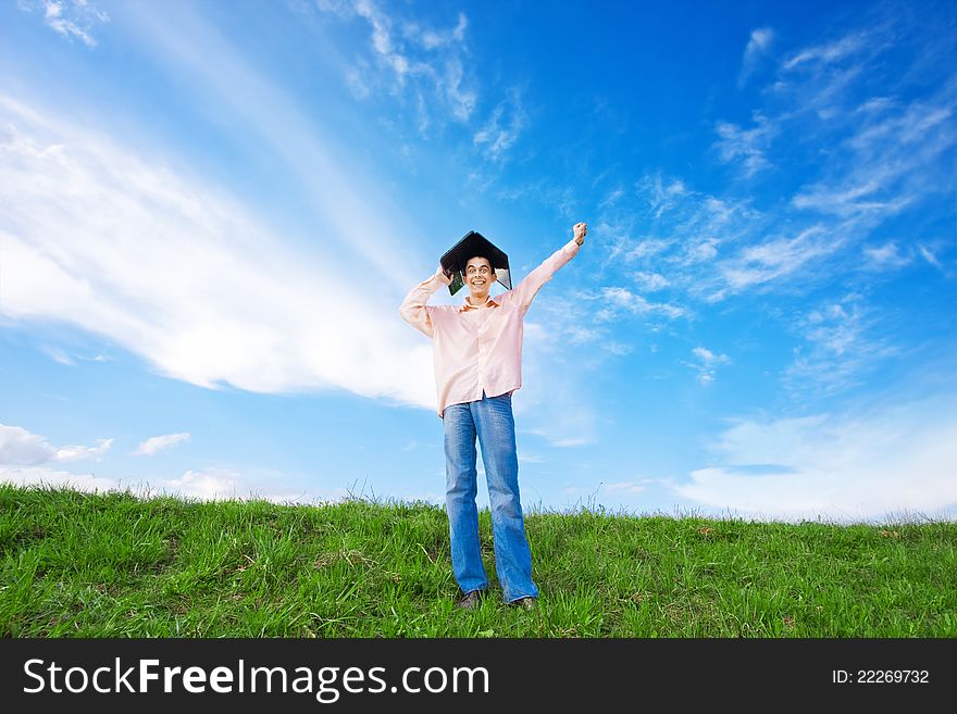 Young man using laptop in the field