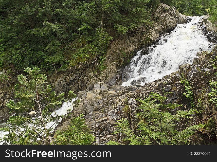 Waters sprays as water churcns through the forest at Lower Split Rock Falls in the Adirondack Mountains of New York. Waters sprays as water churcns through the forest at Lower Split Rock Falls in the Adirondack Mountains of New York
