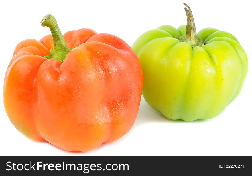 A red and a green bell peppers on a white background. A red and a green bell peppers on a white background