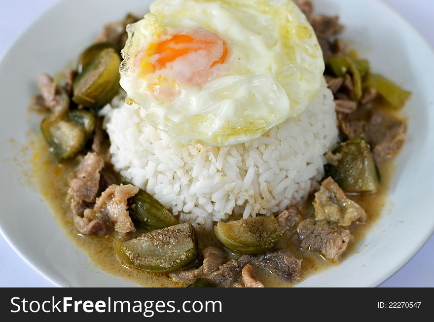 Steamed rice served with fried eggs and beef in ground peanut-coconut cream curry. Steamed rice served with fried eggs and beef in ground peanut-coconut cream curry