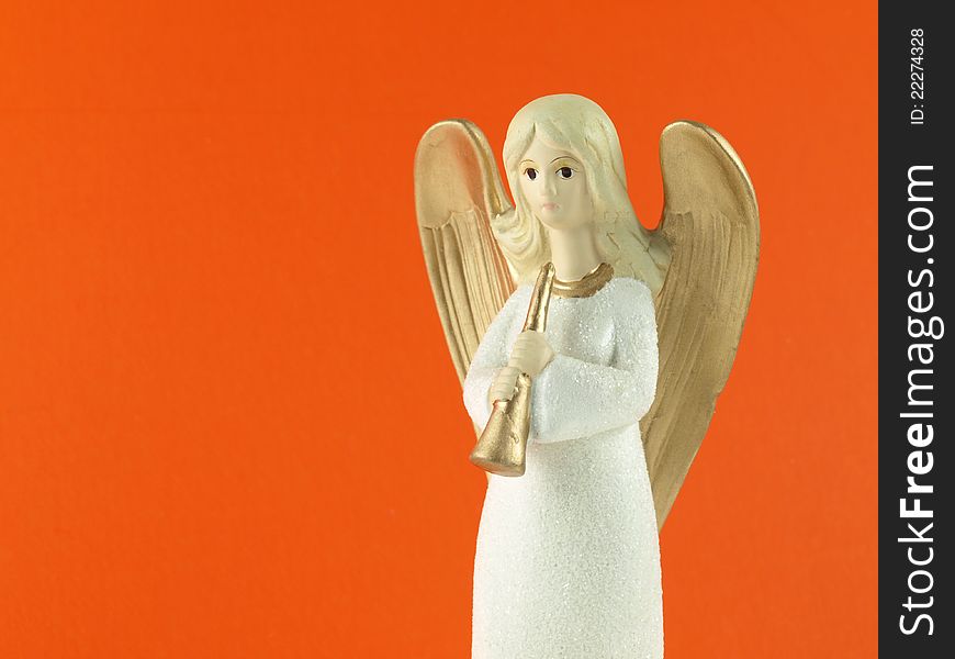 Christmas angel with a trumpet on orange background