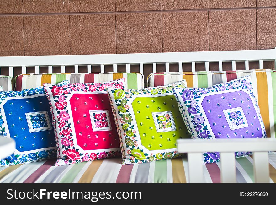 Colorful pillows with brown brick wall