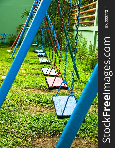 Blue and red swings hanging in the park for kids