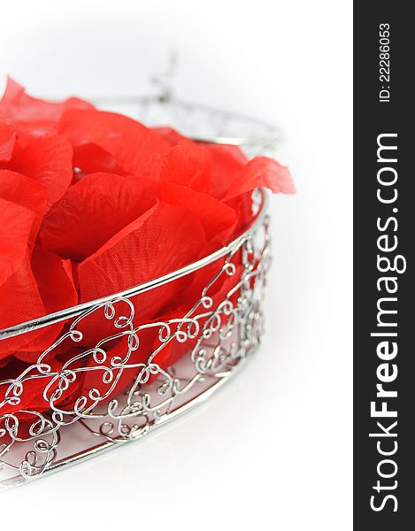 Shining metal box with rose petals  on white