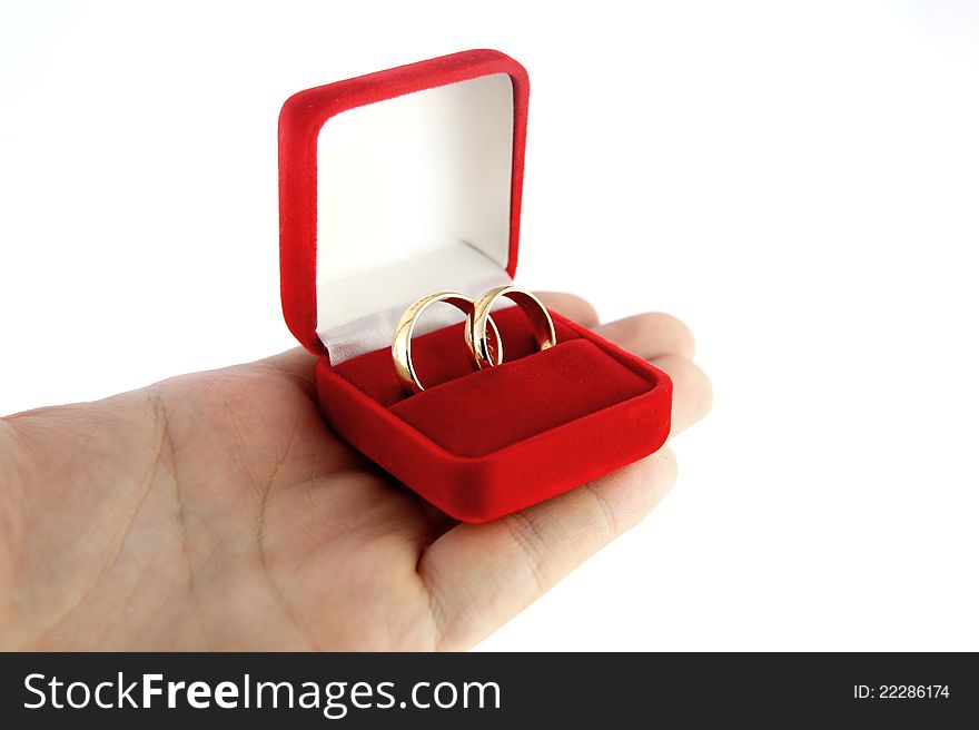 Hand holding a box with wedding rings isolated on white background