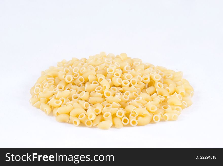 Uncooked small pasta horns with white background