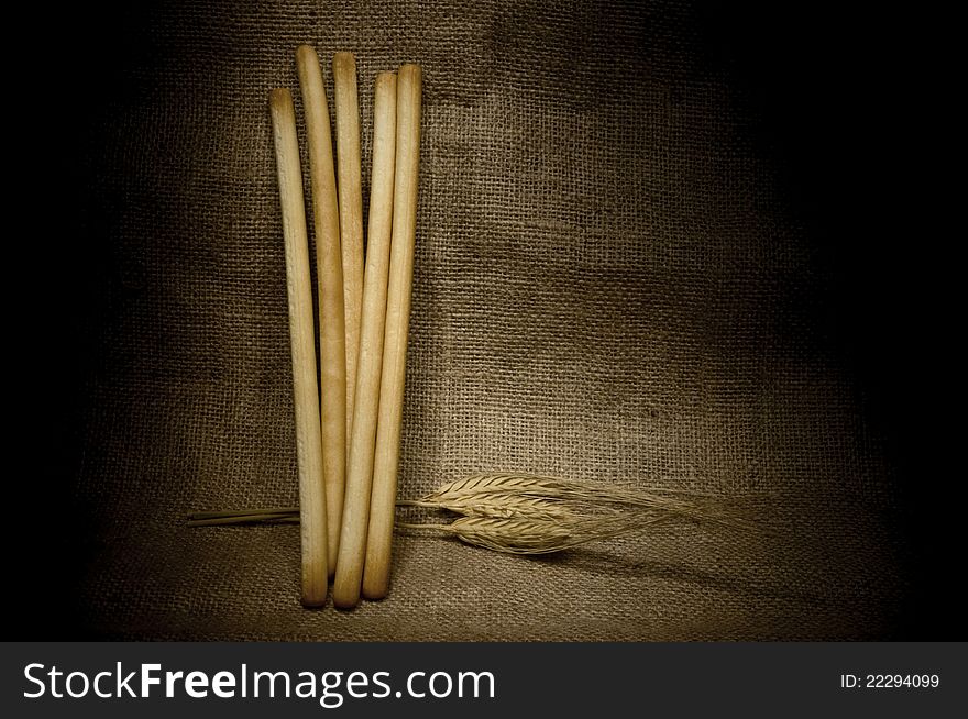 Still life with bread sticks and wheat ears