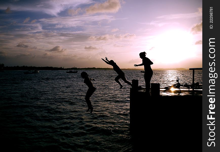Teen girls jumping off the pier into the sea - Brazil. Teen girls jumping off the pier into the sea - Brazil