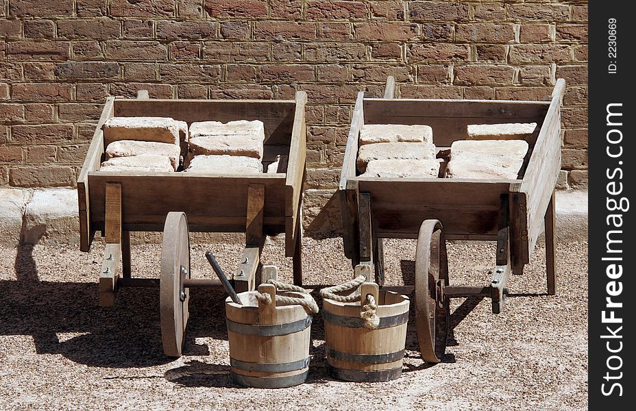 Old Wooden Wheelbarrows And Buckets Filled With Bricks. Old Wooden Wheelbarrows And Buckets Filled With Bricks