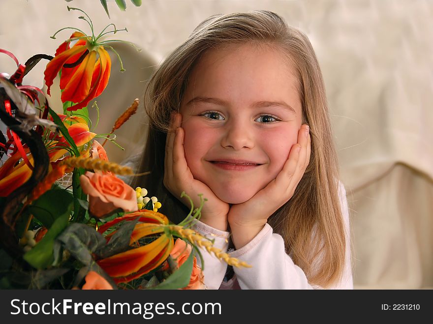 Portrait of a little girl next to a bunch of flowers
